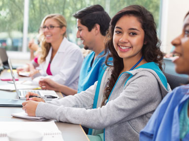 Eine Lerngruppe von Schülern bzw. Abiturienten in der Schule schauen in die Kamera