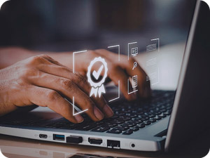 Hände auf dem Schreibtisch mit einem Buch, Notizzetteln und einem Laptop